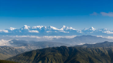 “Snow-capped Himalayan peaks seen from Kumaon Hills, Uttarakhand during sunrise – peaceful weekend getaway destination.”